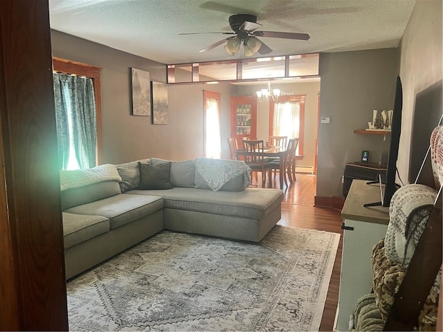 living room with a ceiling fan, a textured ceiling, wood finished floors, a chandelier, and baseboard heating