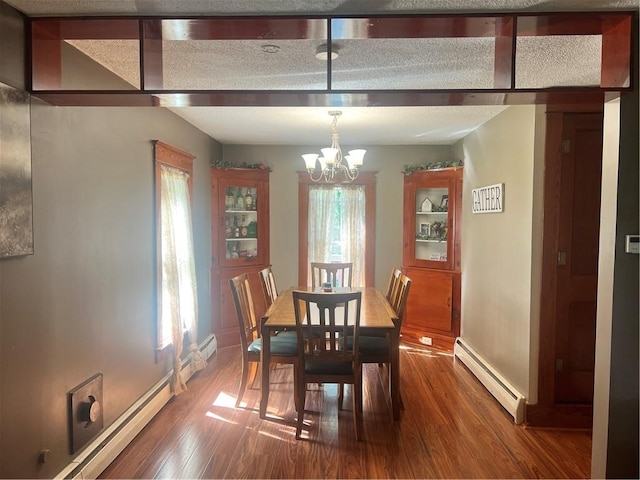dining room with a baseboard radiator, a chandelier, baseboards, and wood finished floors