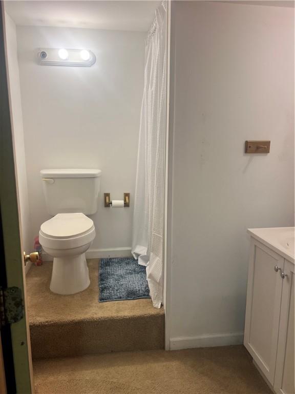 full bath with toilet, vanity, a shower with shower curtain, and baseboards