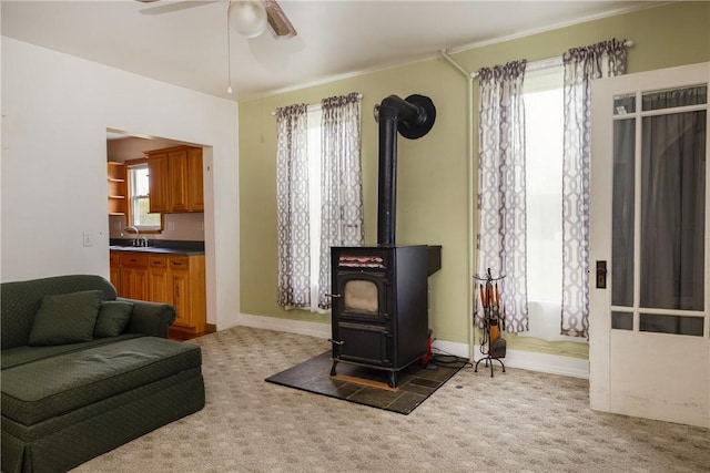 448 Old Ithaca Rd, Horseheads, NY 14845 - living area featuring a wood stove, carpet, a ceiling fan, and baseboards