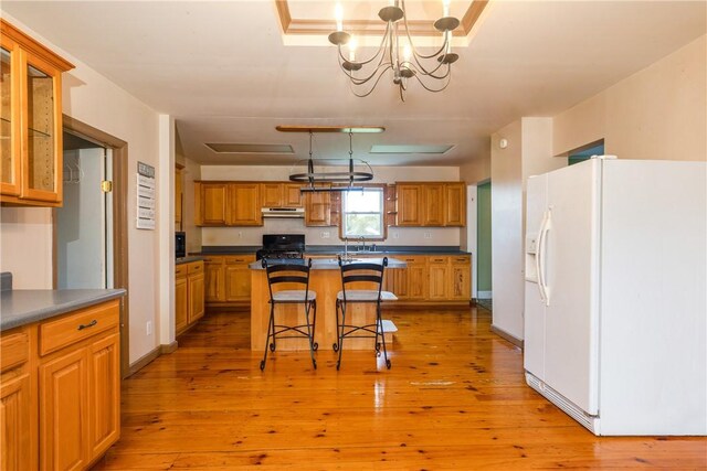448 Old Ithaca Rd, Horseheads, NY 14845 - kitchen featuring white refrigerator with ice dispenser, under cabinet range hood, dark countertops, and a kitchen bar