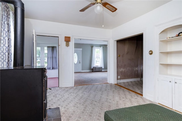 448 Old Ithaca Rd, Horseheads, NY 14845 - unfurnished dining area featuring a wood stove, ceiling fan, radiator, carpet, and built in features