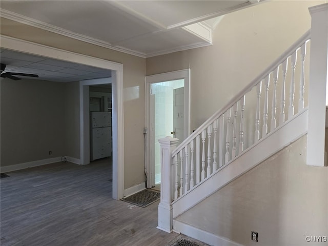 stairway with wood finished floors, baseboards, crown molding, and a ceiling fan