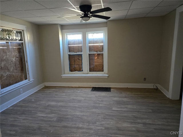 unfurnished room featuring a paneled ceiling, baseboards, a ceiling fan, and wood finished floors