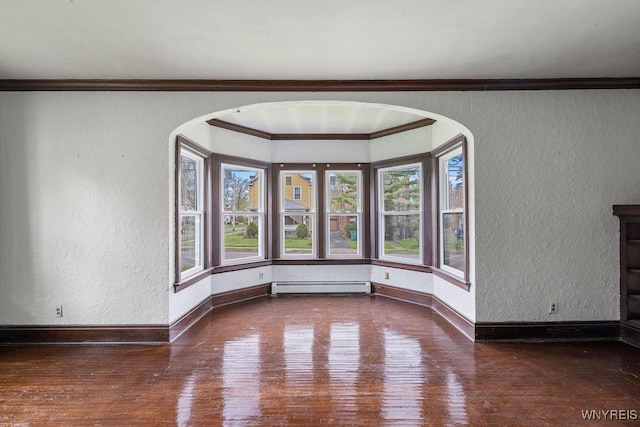 unfurnished room with a textured wall, arched walkways, hardwood / wood-style flooring, baseboard heating, and baseboards