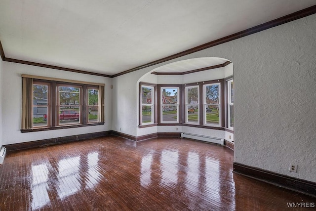 empty room featuring baseboard heating, arched walkways, a textured wall, hardwood / wood-style flooring, and crown molding