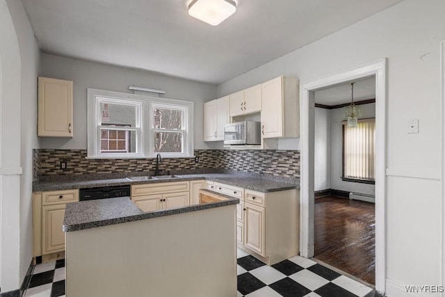 kitchen with light floors, a sink, stainless steel microwave, and plenty of natural light