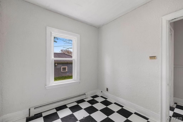empty room featuring a baseboard heating unit and tile patterned floors