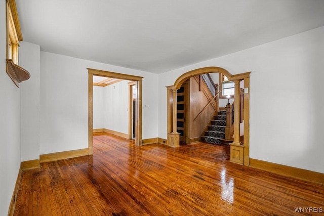 44 Christiana St, North Tonawanda, NY 14120 - unfurnished room featuring wood-type flooring, arched walkways, stairway, and baseboards