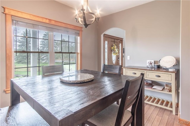 20948 Nys Rte 180, Hounsfield, NY 13634 - dining space featuring a chandelier, arched walkways, and light wood-style flooring