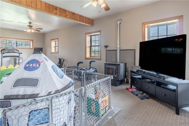 20948 Nys Rte 180, Hounsfield, NY 13634 - living area featuring ceiling fan, a wood stove, beamed ceiling, and tile patterned flooring