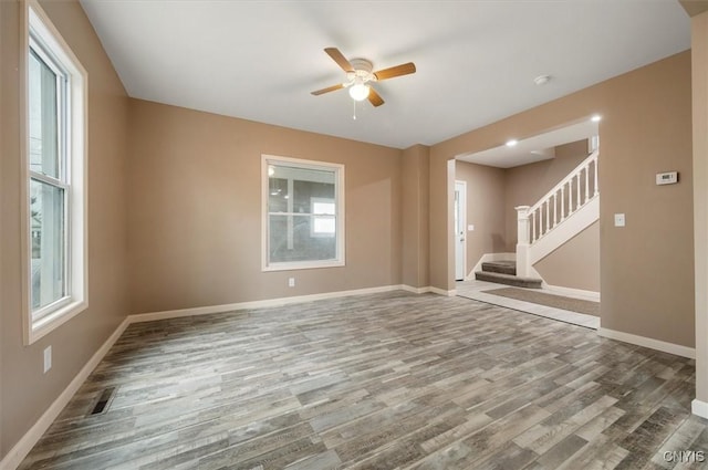 212 N Broad St, Oneida-Inside, NY 13421 - spare room with wood finished floors, ceiling fan, baseboards, and stairway
