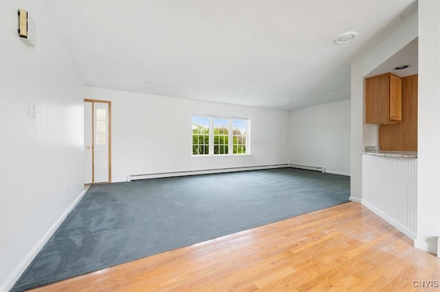 120 Getmac Ave, Lenox, NY 13032 - unfurnished living room featuring baseboard heating, baseboards, light colored carpet, and light wood-style flooring