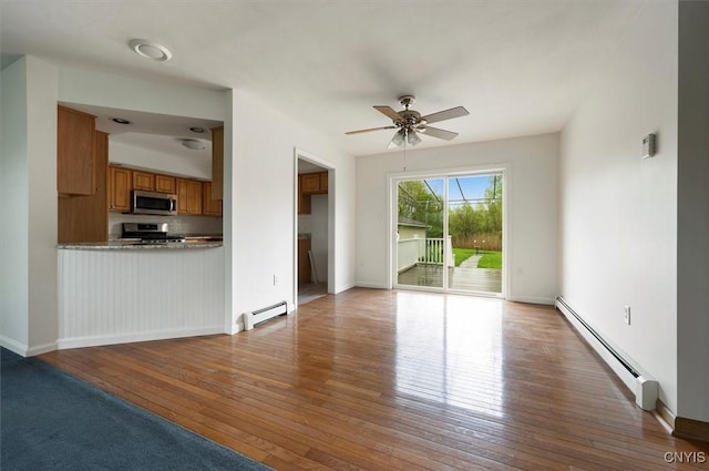 120 Getmac Ave, Lenox, NY 13032 - unfurnished living room featuring baseboard heating, hardwood / wood-style floors, a ceiling fan, and baseboards