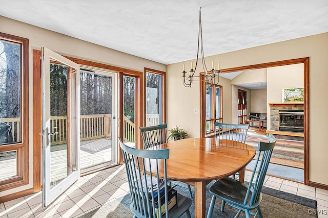 7629 Creek Farm Ln, Trenton, NY 13354 - dining space featuring light tile patterned floors, plenty of natural light, a chandelier, and a fireplace