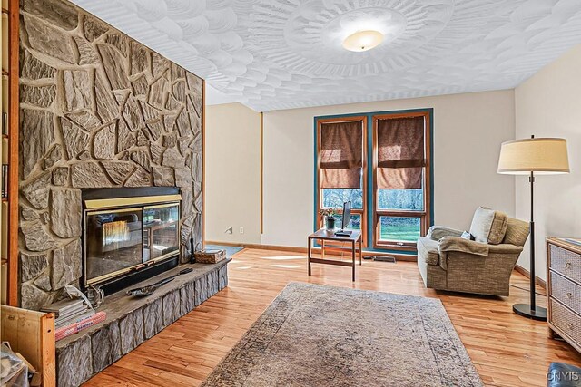 7629 Creek Farm Ln, Trenton, NY 13354 - living room featuring baseboards, wood-type flooring, and a stone fireplace