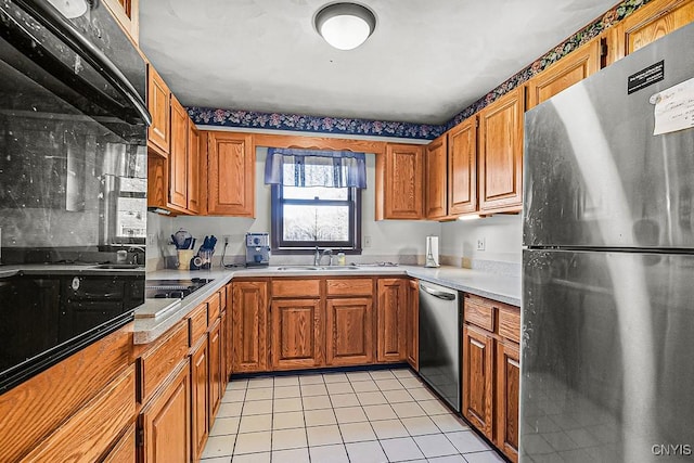 7629 Creek Farm Ln, Trenton, NY 13354 - kitchen with black appliances, brown cabinetry, a sink, and light tile patterned floors