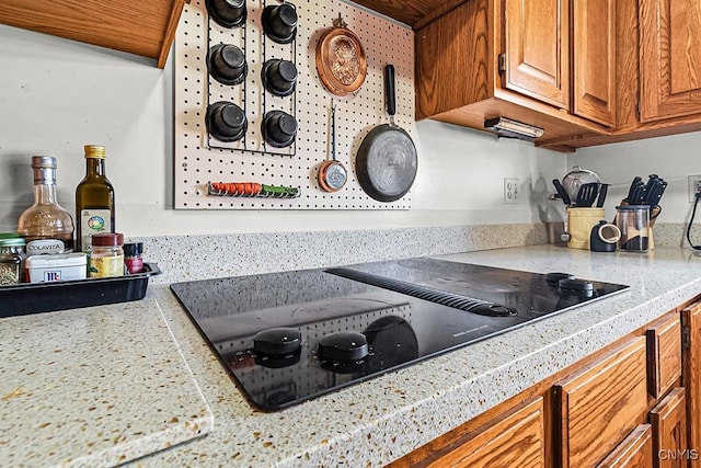 7629 Creek Farm Ln, Trenton, NY 13354 - kitchen with black electric cooktop, brown cabinets, and tile countertops