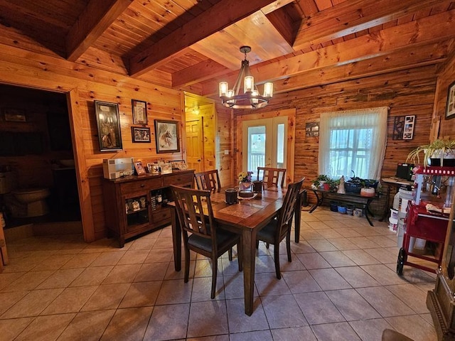 4138 Hubbs Rd, Hector, NY 14818 - dining space featuring wood walls, wooden ceiling with exposed beams, light tile patterned floors, a chandelier, and french doors