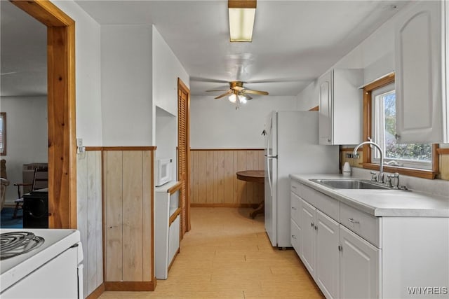 449 Madison Ave, Evans, NY 14006 - kitchen with a sink, wainscoting, ceiling fan, white appliances, and white cabinets