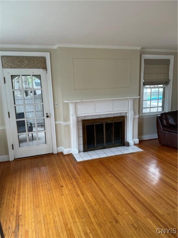 10 Sage Ct, Utica, NY 13502 - unfurnished living room featuring a fireplace, light wood-style floors, baseboards, and crown molding