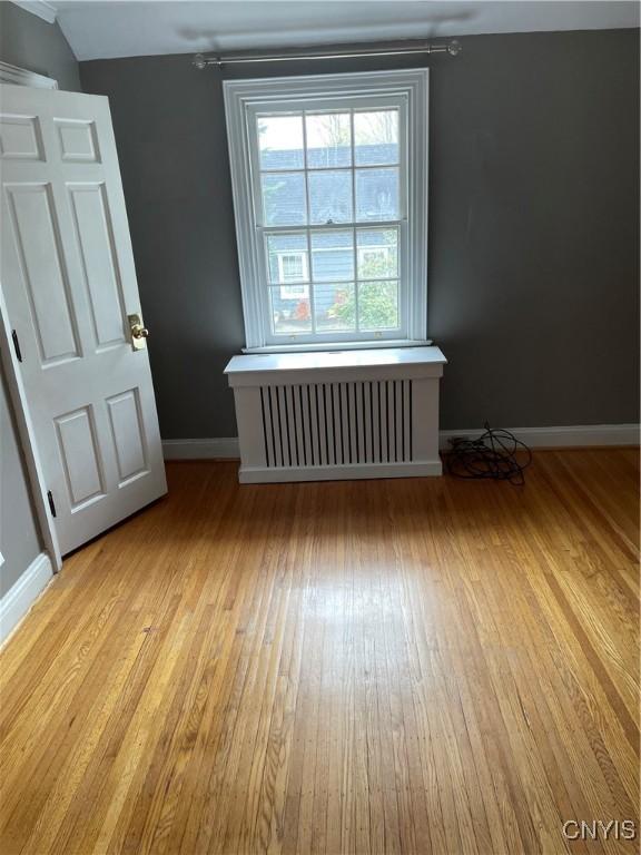 10 Sage Ct, Utica, NY 13502 - empty room featuring light wood-style flooring, radiator heating unit, and baseboards
