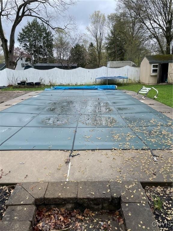 10 Sage Ct, Utica, NY 13502 - view of swimming pool with a trampoline, a storage unit, and an outbuilding