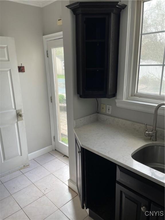 10 Sage Ct, Utica, NY 13502 - kitchen featuring a sink, plenty of natural light, light tile patterned flooring, and dark cabinets