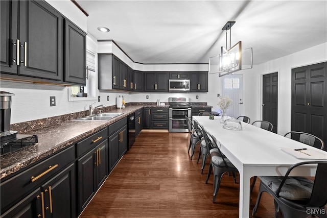 7678 Totman Rd, Cicero, NY 13212 - kitchen featuring stainless steel appliances, a sink, a kitchen bar, dark wood-type flooring, and dark countertops
