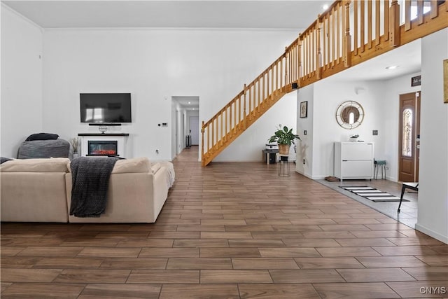7678 Totman Rd, Cicero, NY 13212 - living room with dark wood finished floors, stairway, a high ceiling, a glass covered fireplace, and baseboards