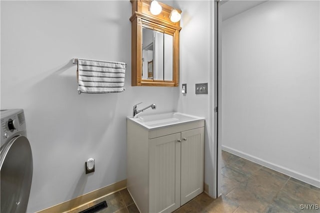 7678 Totman Rd, Cicero, NY 13212 - bathroom featuring washer / clothes dryer, baseboards, stone finish floors, and vanity