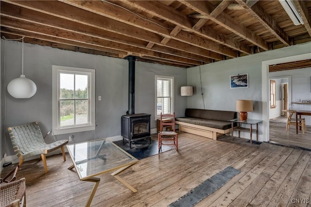 3323 County Route 95, Worth, NY 13659 - living room with wood-type flooring, a wood stove, and healthy amount of natural light
