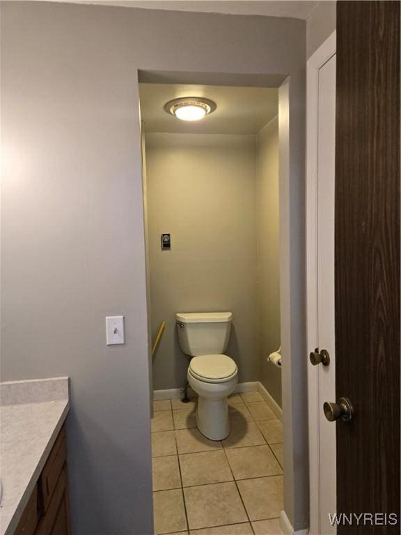 bathroom with tile patterned floors, toilet, vanity, and baseboards