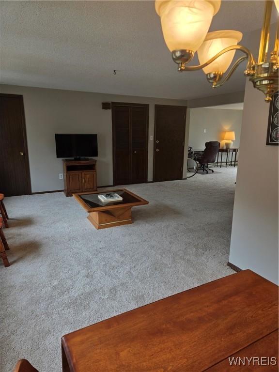 carpeted living room with a chandelier
