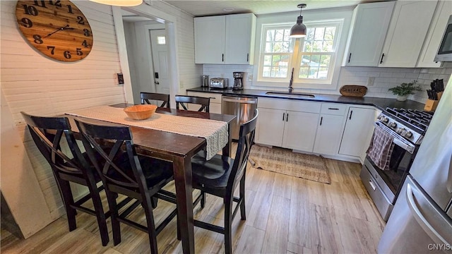 5416 W Lake Rd, Fleming, NY 13021 - kitchen with a sink, dark countertops, tasteful backsplash, light wood-type flooring, and wood walls