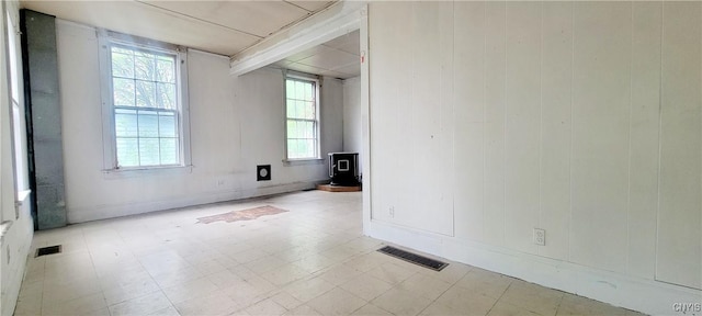 416 Pond St, Rome-Inside, NY 13440 - unfurnished room with a wood stove, healthy amount of natural light, tile patterned floors, and baseboards