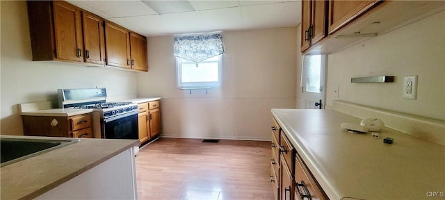 416 Pond St, Rome-Inside, NY 13440 - kitchen featuring white gas stove, brown cabinetry, light wood-style floors, and baseboards