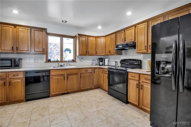 761 Pletcher Rd, Lewiston, NY 14092 - kitchen with black appliances, a sink, under cabinet range hood, backsplash, and brown cabinetry
