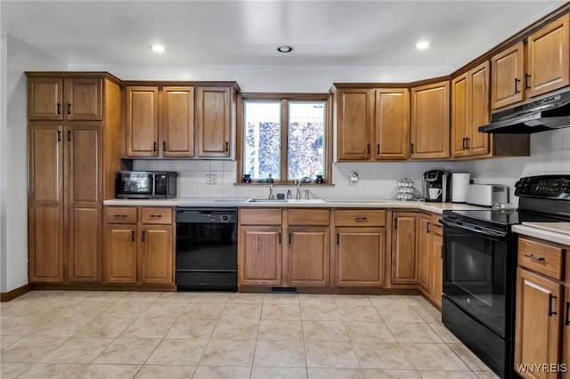 761 Pletcher Rd, Lewiston, NY 14092 - kitchen featuring black appliances, under cabinet range hood, a sink, brown cabinetry, and light countertops