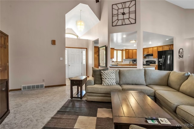 761 Pletcher Rd, Lewiston, NY 14092 - living area featuring a towering ceiling, carpet floors, baseboards, and a chandelier