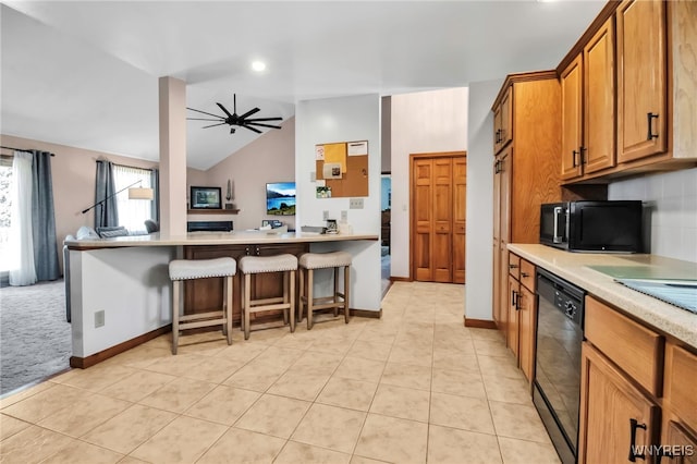 761 Pletcher Rd, Lewiston, NY 14092 - kitchen with black appliances, a kitchen bar, brown cabinets, light countertops, and lofted ceiling