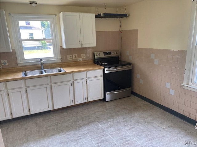 138 W Lynhurst Ave, Syracuse, NY 13205 - kitchen with stainless steel electric stove, light countertops, white cabinets, and tile walls
