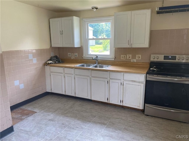 138 W Lynhurst Ave, Syracuse, NY 13205 - kitchen with stainless steel electric range oven, tile walls, white cabinetry, light countertops, and wainscoting