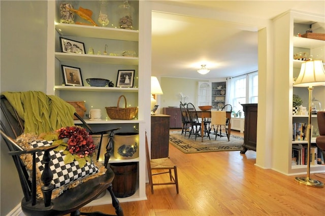77 Hendy Creek Rd, Big Flats, NY 14905 - sitting room featuring radiator heating unit, wood finished floors, and built in shelves