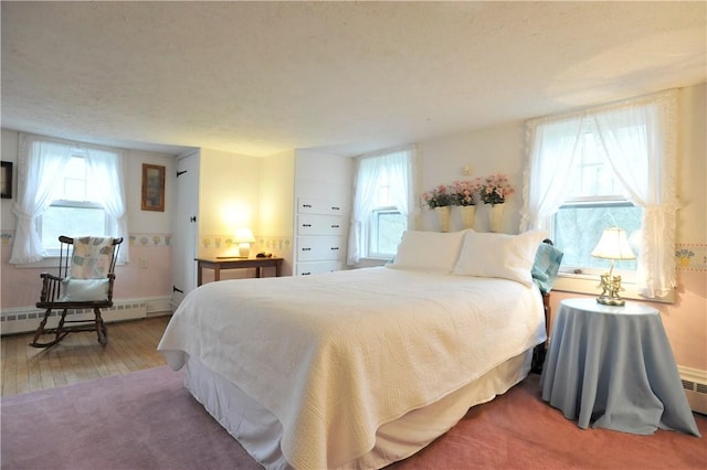 77 Hendy Creek Rd, Big Flats, NY 14905 - bedroom with a baseboard heating unit, wood finished floors, and baseboards