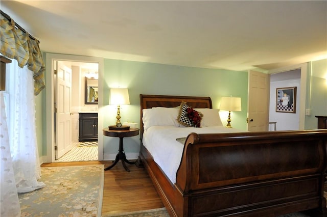 77 Hendy Creek Rd, Big Flats, NY 14905 - bedroom with wood finished floors, connected bathroom, and baseboards