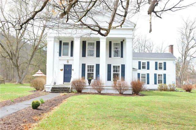 77 Hendy Creek Rd, Big Flats, NY 14905 - neoclassical home featuring a chimney and a front lawn