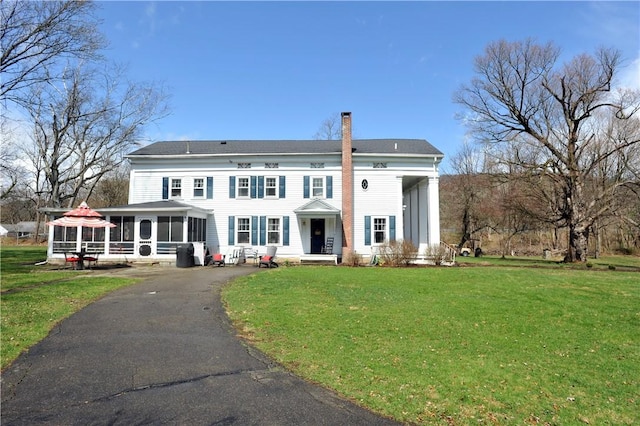77 Hendy Creek Rd, Big Flats, NY 14905 - view of front facade featuring a sunroom, a chimney, a front lawn, and driveway