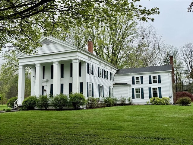 77 Hendy Creek Rd, Big Flats, NY 14905 - view of front of house featuring a chimney, a front lawn, and covered porch