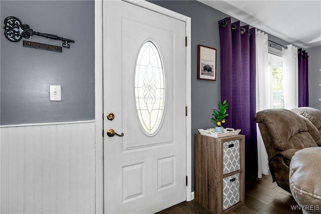 foyer entrance featuring dark wood-type flooring and a wainscoted wall